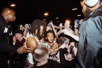 a group of people standing around a man with a microphone