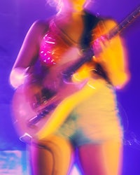 a woman playing an electric guitar on stage