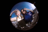 two women are posing for a picture in a fish tank