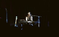 a woman playing a keyboard in a dark room