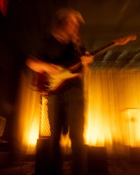a man playing a guitar in a dark room