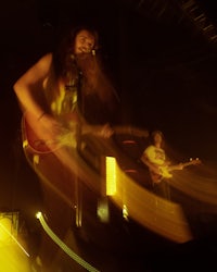 a group of people playing guitar in a dark room