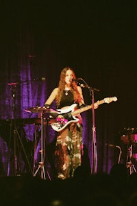 a woman playing a guitar on stage