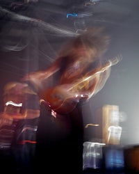 a blurry image of a person playing a guitar